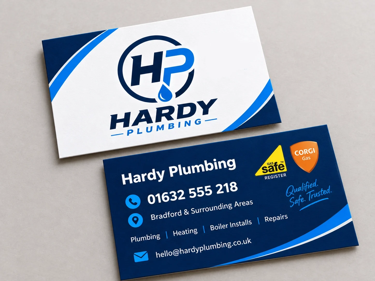 Hardy Plumbing business cards: white front with the HP monogram and full lockup, navy reverse carrying phone number, service list, area covered and email